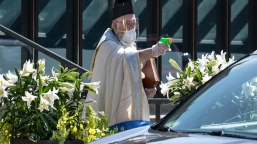 Con una pistola de agua, sacerdote bendice a los fieles