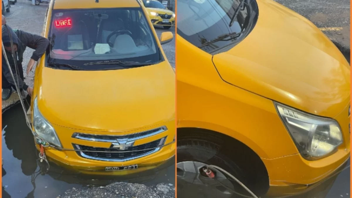 Un taxi quedó atascado en un gran pozo, en el medio de la calle